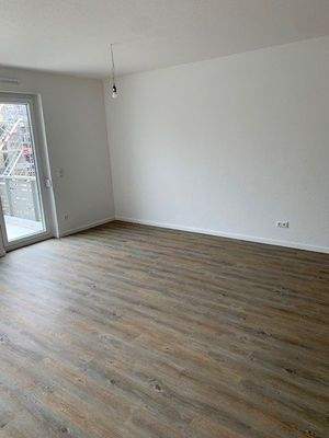 Wohnzimmer mit bodentiefen Fenstern und Vinylboden