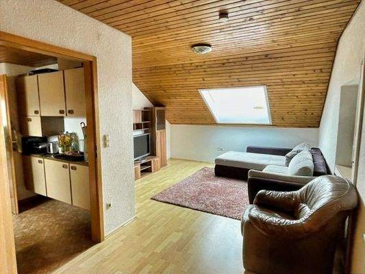 Wohnzimmer mit angrenzender Küche im Dachgeschoss