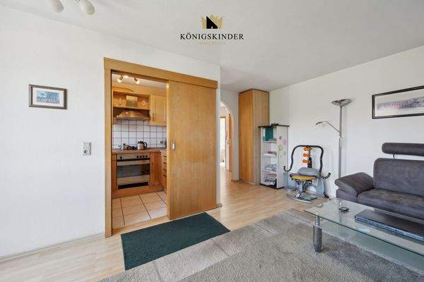 Eine raumsparende Schiebetür verbindet Wohn-Essbereich und Küche. 