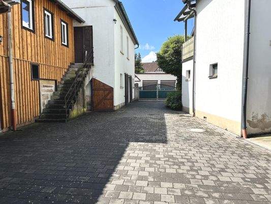 gepflasterter Hof mit Nebengebäuden