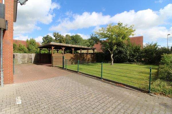 Grünfläche und Doppelcarport neben dem Gebäude