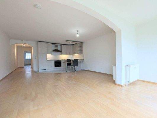 Großes Wohnzimmer mit offener Einbauküche.