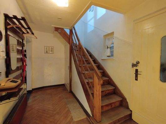Eingang im Erdgeschoss mit Echtholzfussboden und massiver Treppe