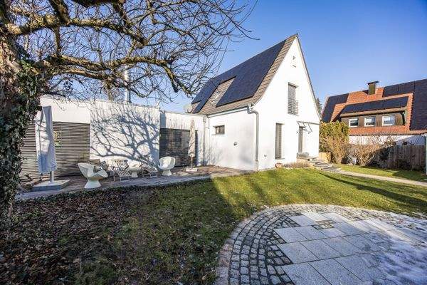 Außenansicht des Hauses mit sonniger Terrasse, Sitzbereich und angrenzendem Garten