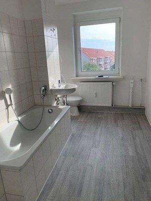 Badezimmer mit Badewanne und Vinylfußboden