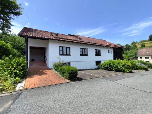 Ansicht Nordost mit Stellplätzen und Eingang Gewerbe