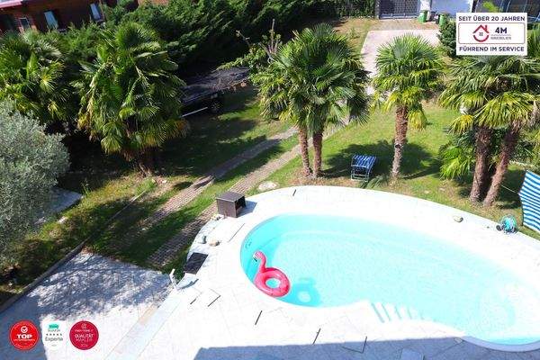 Dachzimmer mit Blick auf Pool, Garten und Palmen