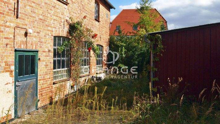 Innenhof mit Zugang zum verwunschenen Garten