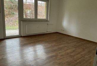 Wohnzimmer mit Panoramafenster und Zugang zum Balkon