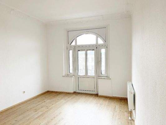 Schlafzimmer mit Stuckdecke und Blick Richtung kleinem Balkon