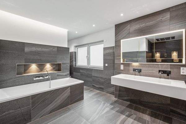 Das Masterbad im ersten Obergeschoss präsentiert sich mit allen Annehmlichkeiten wie der geräumigen Regenwalddusche