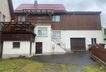 Hausansicht mit Großgarage und überdachte Balkonen und Hof