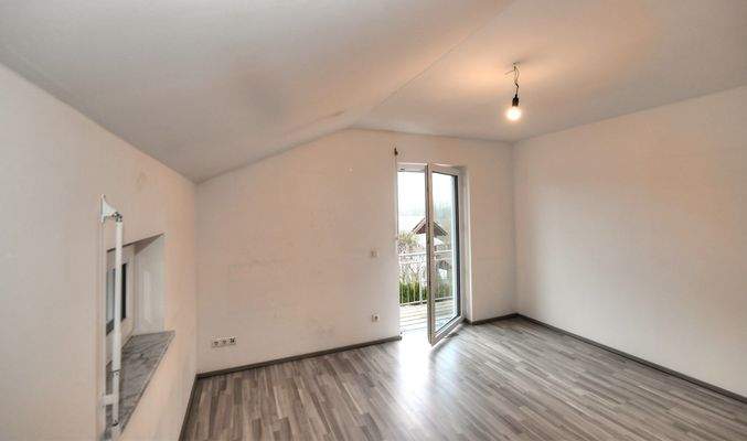 Zimmer im Obergeschoss mit Zugang zum Balkon
