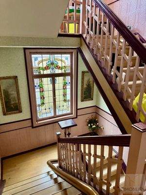 Treppenhaus mit dekorativem Bleiglasfenster