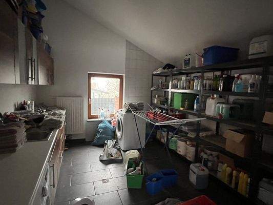 Geräuschvoller Hauswirtschaftsraum mit viel Stauraum und Waschmaschine