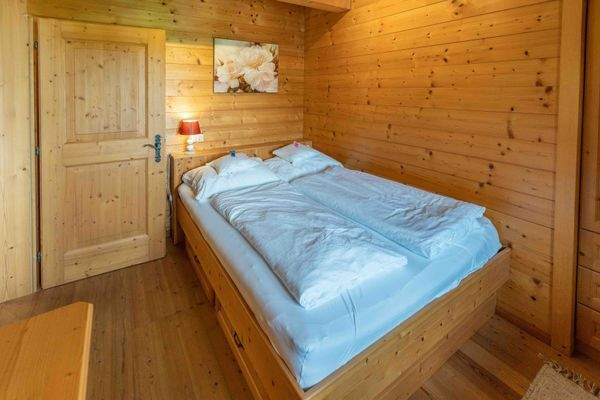 Schlafzimmer mit Doppelbett und Holzverkleidung – rustikal und einladend.