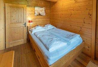 Schlafzimmer mit Doppelbett und Holzverkleidung – rustikal und einladend.