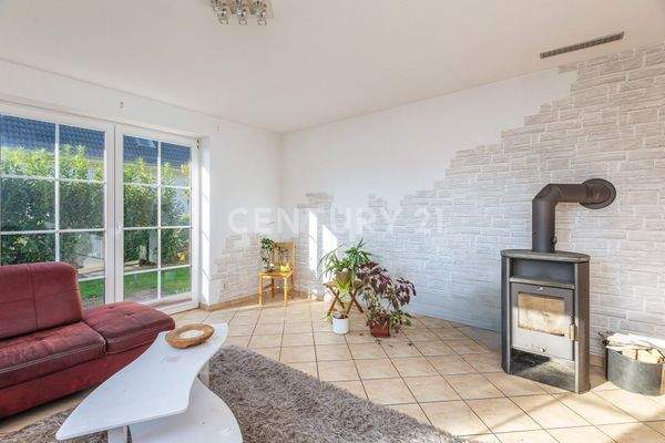 Wohnzimmer mit Kamin und Terrassenzugang