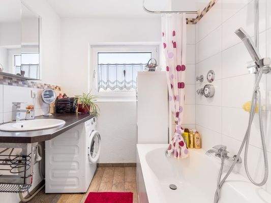 Tageslichtbadezimmer mit Badewanne, Dusche und Waschmaschinenanschluss