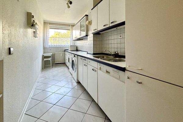 Küche mit Einbaumöbeln und Waschmaschine