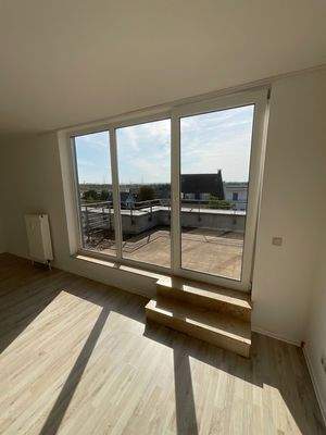 Wohnzimmer mt Zugang zum Balkon und bodentiefen Fenstern.jpg