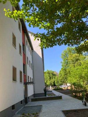 Vorderansicht Gebäude mit Hausansicht, Eingängen und Begrünung