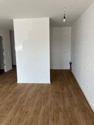 Blick in den Küchenbereich, weiße Wände, brauner Vinyl-Designboden in Holzoptik