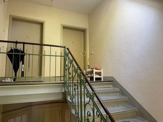 Treppenhaus mit Wohnungstür rechts