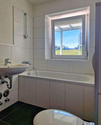 Zeitloses, weißes Bad mit Fenster