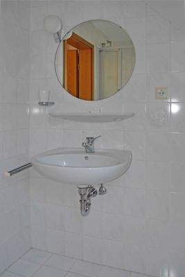 Bad mit Waschbecken und Spiegel