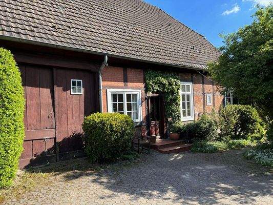 Seitenansicht mit Parkfläche vor dem Haus und dem alten Dielentor