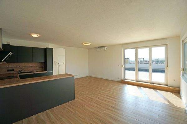 Wohnzimmer mit offener Küche, Klimaanlage und Ausgang auf die Dachterrasse