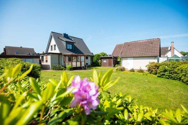 Haus von hinten mit Garten, links Garage und rechts Werkstatt