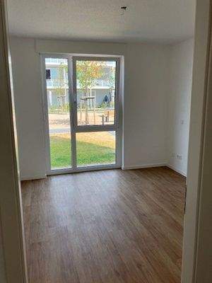 Schlafzimmer mit weißen Wänden, brauner Vinyl-Designboden in Holzoptik