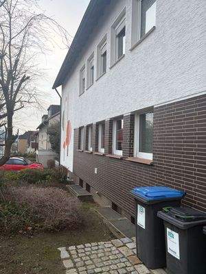 Hausfassade mit Mülltonnen