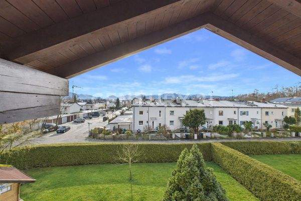 Gartenansicht mit Wohnhäusern und Bergen