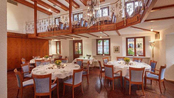 Vielseitiger Veranstaltungsraum in warmen Holztönen und imposant gestalteter Empore