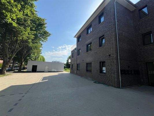 Ansicht mit Parkplatz und Abestellräume 