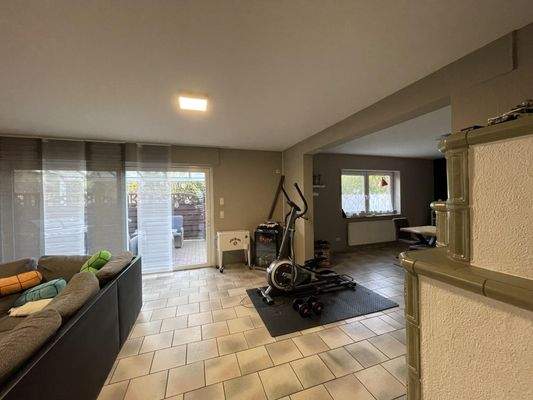 Wohnzimmer mit Kachelofen und Zugang zur Terrasse