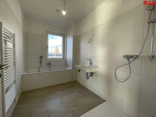 Badezimmer mit Dusche, Badewanne und Fenster