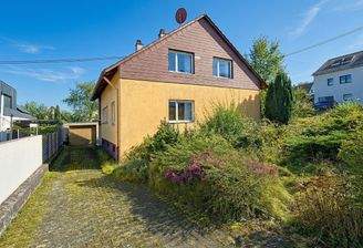 Hausansicht mit Vorgarten, Garage und Zufahrt