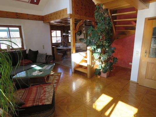 Wohnzimmer mit offener Holztreppe zur Galerie 