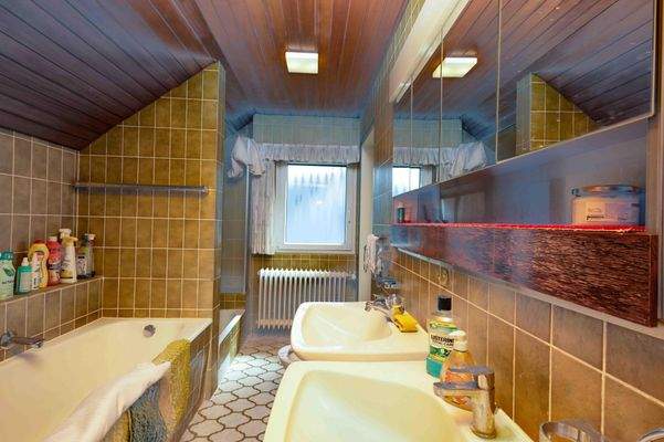 Badezimmer im Dachgeschoss mit zwei Waschbecken, Dusche und Badewanne