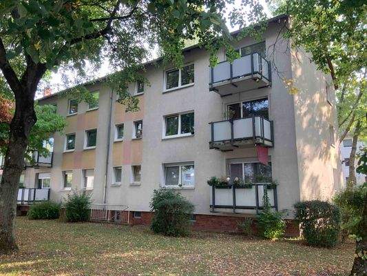 Rückansicht eines Mehrfamilienhauses mit Balkonen.