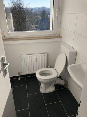 Badezimmer weiß gefliest mit Fenster und dunklem Fiiesenboden.jpg