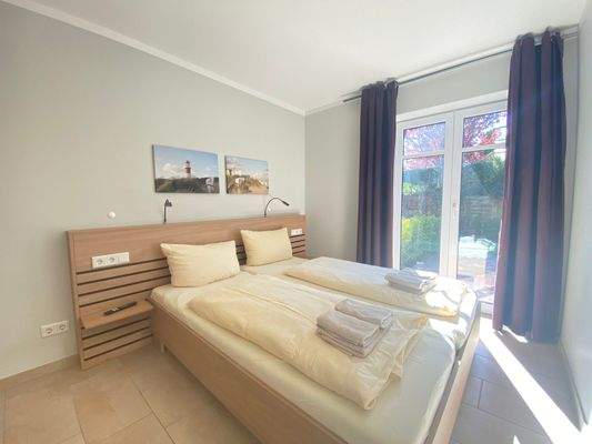 Schlafraum mit Doppelbett und Zugang zur Terrasse 