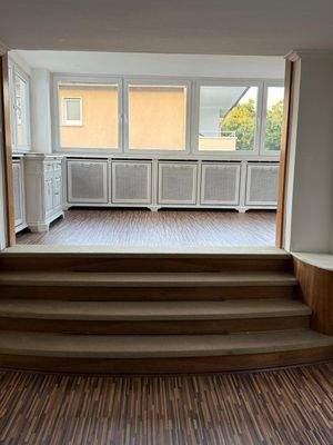 Elegante Panorama-Loggia mit integrierter Heizkörperverkleidung und stufenförmigem Zugang - Lichtdurchfluteter Wohnkomfort auf höchstem Niveau!