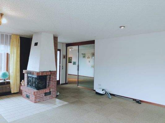 Das Wohnzimmer mit dem Kamin und Galsschiebetür