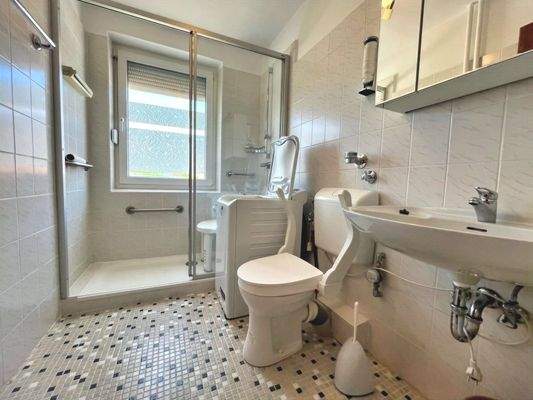 Die fast bodengleiche Dusche wird mit einer Schiebetür verschlossen