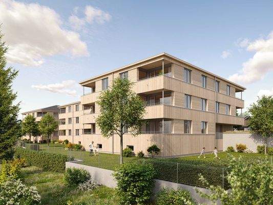 Zwei moderne Mehrfamilienhäuser mit Holzfassaden und Balkonen, umgeben von gepflegten Gärten mit spielenden Kindern unter blauem Himmel (Riedstrasse, Hohenweiler).